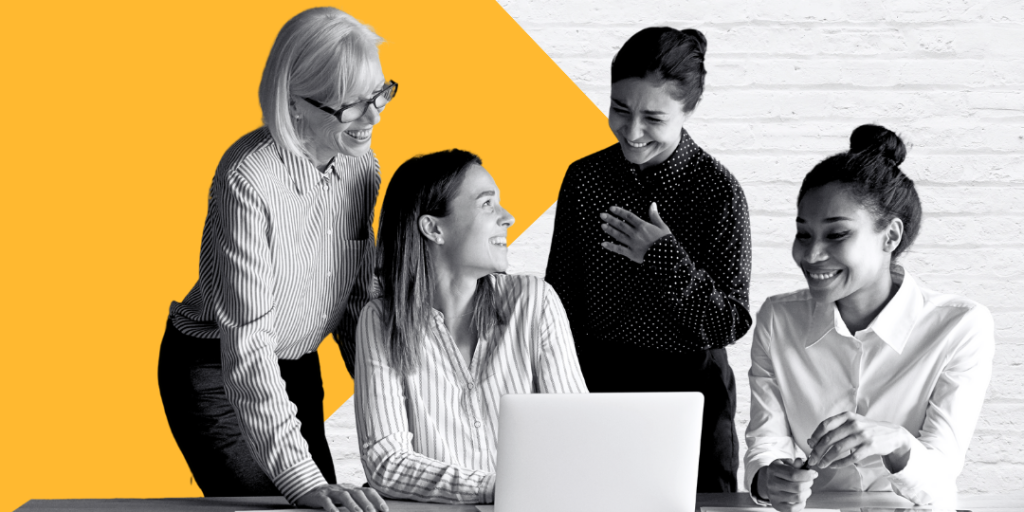 Four women looking at a laptop on a table